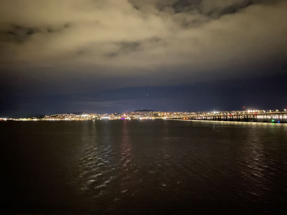 A view of city lights reflected on water at night at Lazy Bulldog in Newport-On-Tay