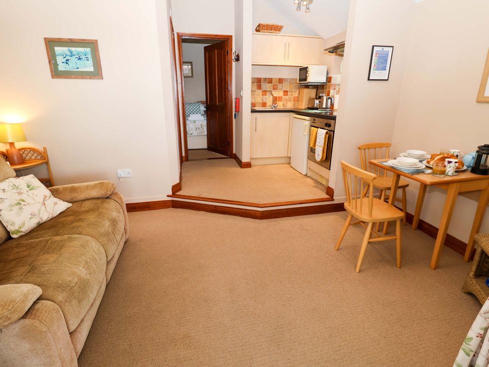 A living room with a sofa and dining area at Hayloft in Ipswich