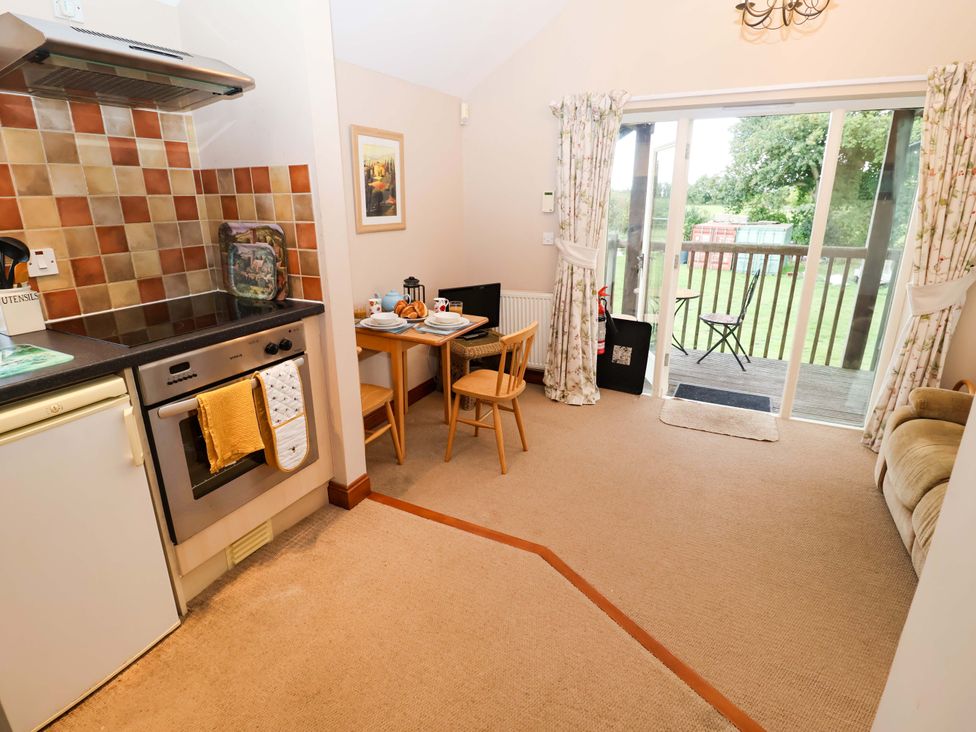 A kitchen with a table and chairs at Hayloft Ipswich