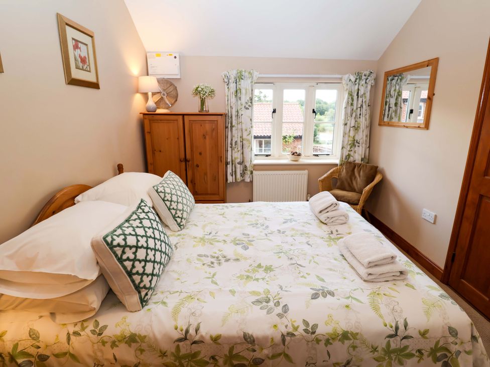 A bedroom with a bed and wardrobe at Hayloft in Ipswich