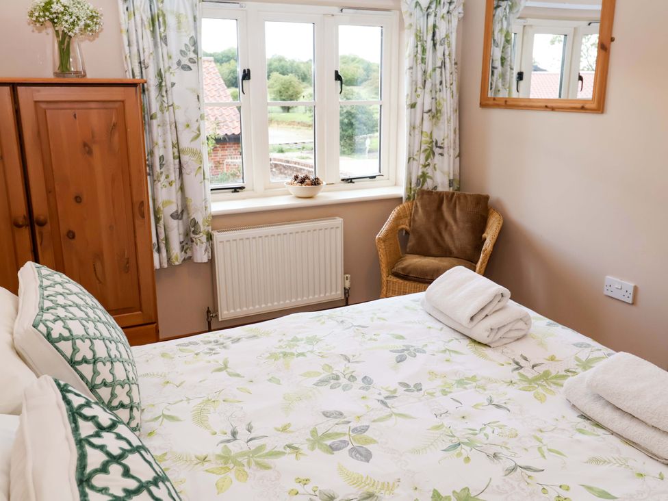 A bedroom with a bed and wardrobe at Hayloft in Ipswich