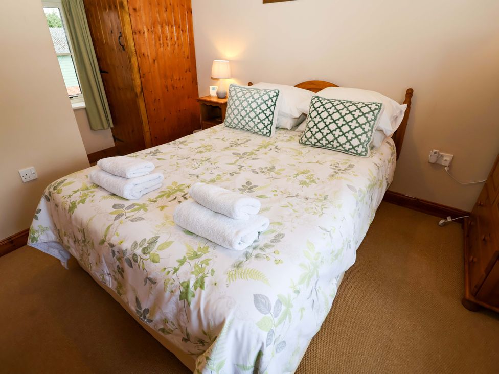 A bedroom with a bed and wardrobe at Hayloft in Ipswich