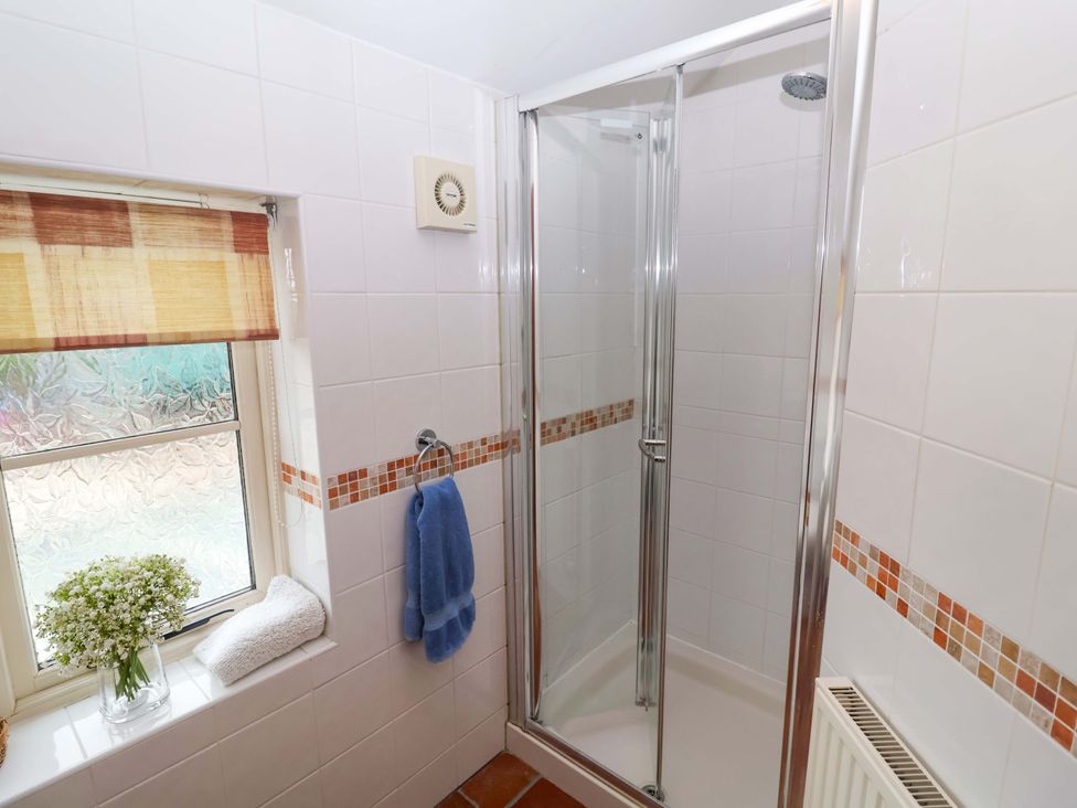 A bathroom with a shower stall and a window at Hayloft in Ipswich
