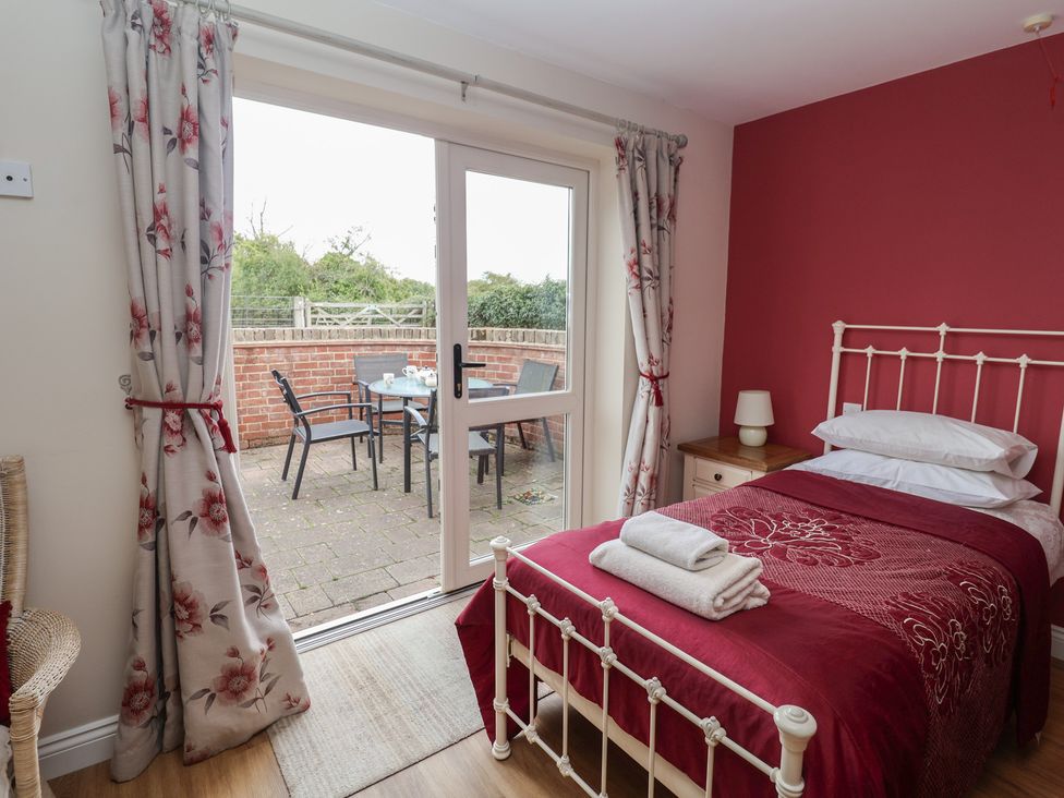 A bedroom with a bed and sliding door to a patio at Fisherman's Rest in Ipswich