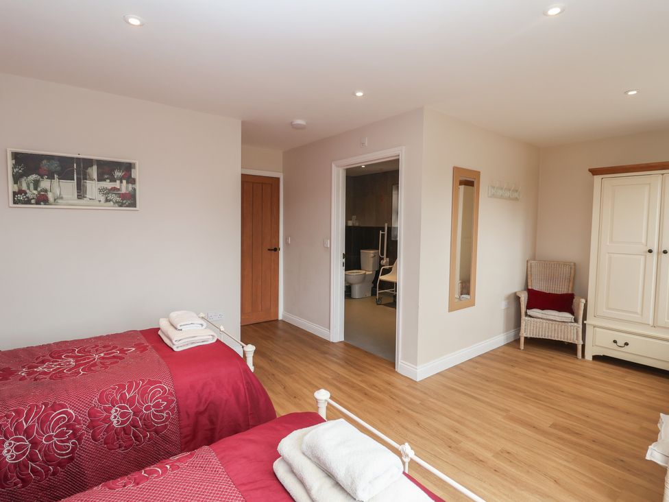 A bedroom with two beds and a chair at Fisherman's Rest in Ipswich