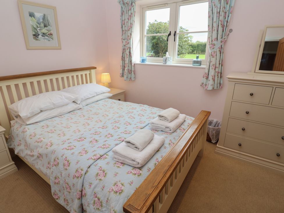A bedroom with a double bed and dresser at Fisherman's Rest in Ipswich