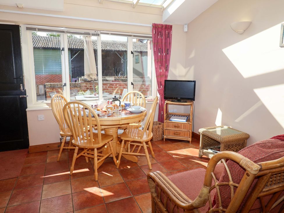 A dining room with a table and chairs at Coachman's Cottage, Ipswich