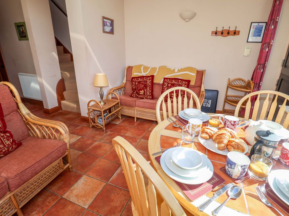 A dining room with a table and chairs at Coachman's Cottage in Ipswich