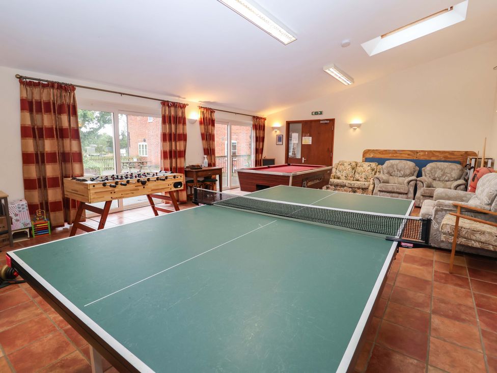 A recreation room with a ping pong table and foosball table at Coachman's Cottage Ipswich