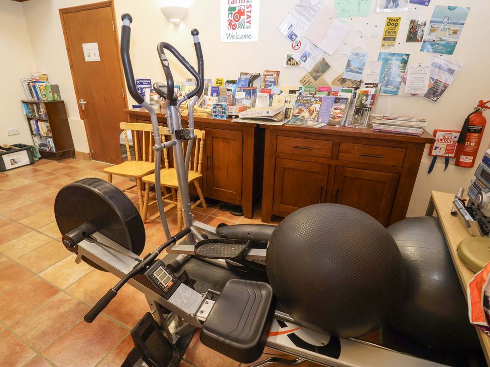 A gym area with an elliptical machine and exercise balls at Coachman's Cottage in Ipswich