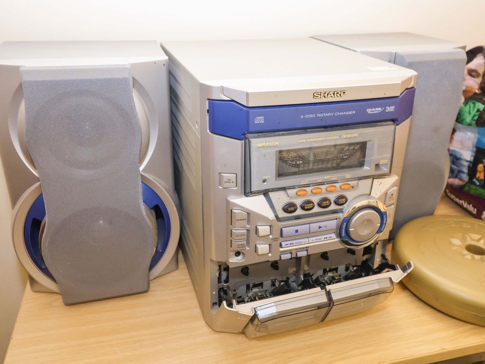 A CD player with speakers on a shelf at Coachman's Cottage in Ipswich