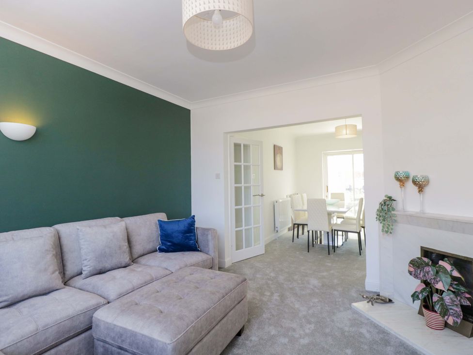 A living room with a sofa and doorway to the dining area at 6 Newbridge Gardens in Bath