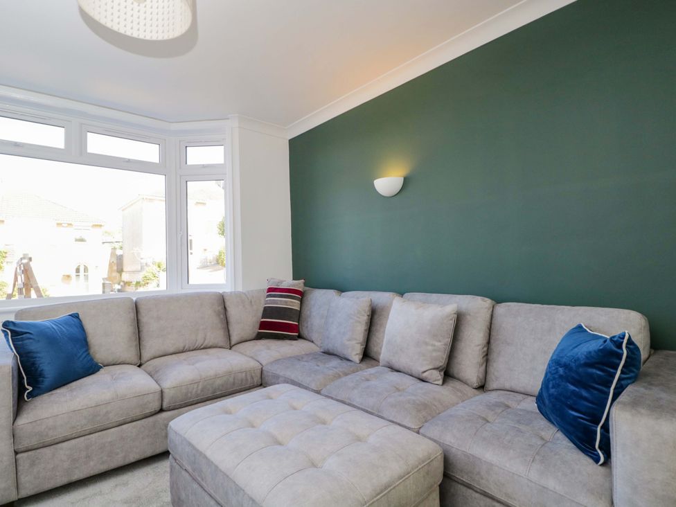A living room with a gray sofa and blue cushions at 6 Newbridge Gardens Bath