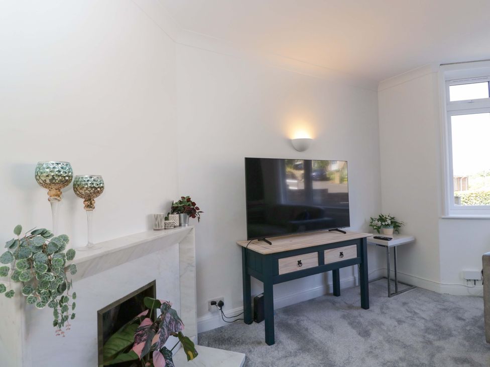 A living room with a television and a coffee table at 6 Newbridge Gardens in Bath