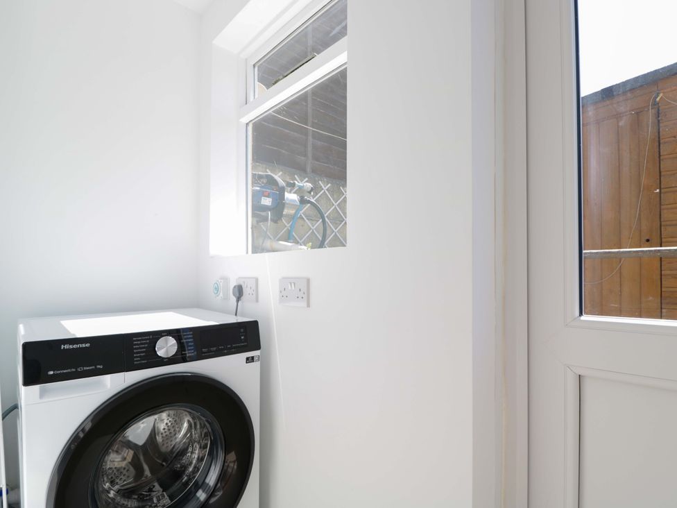A laundry room with a washing machine and a window at 6 Newbridge Gardens in Bath