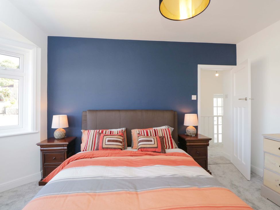 A bedroom with a bed and nightstands at 6 Newbridge Gardens in Bath