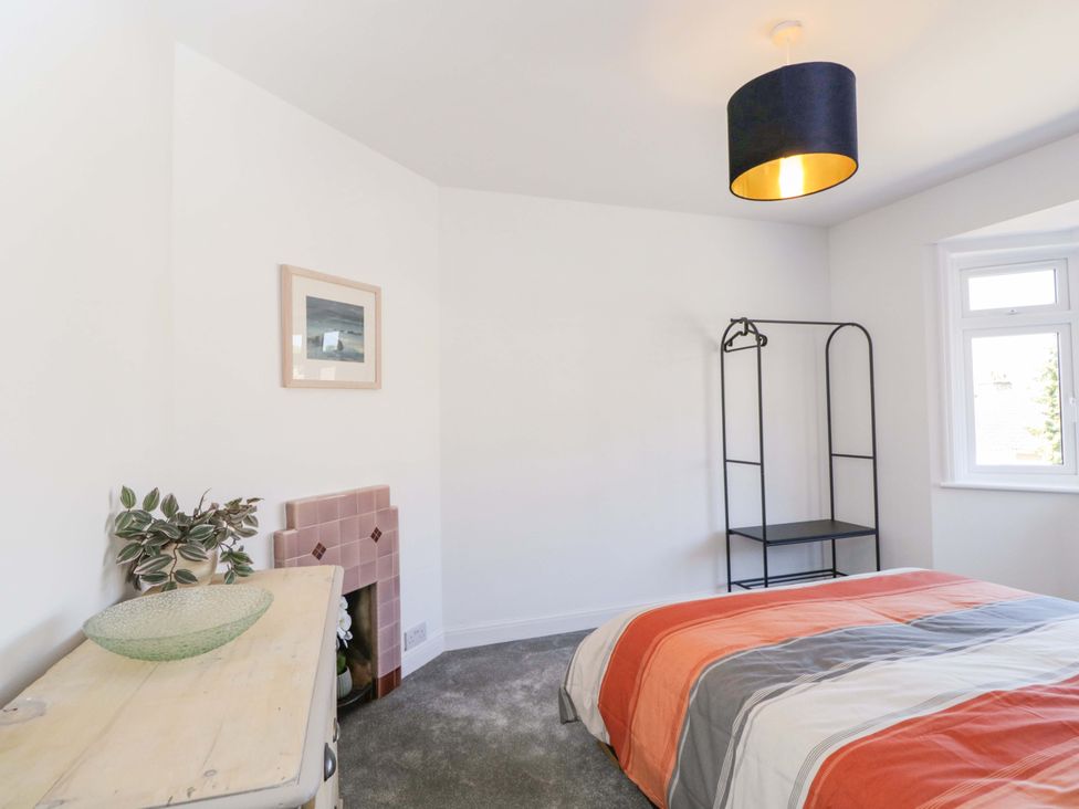 A bedroom with a bed and shelf at 6 Newbridge Gardens in Bath