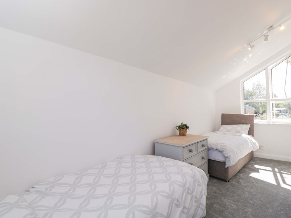 A bedroom with two beds and a window at 6 Newbridge Gardens Bath