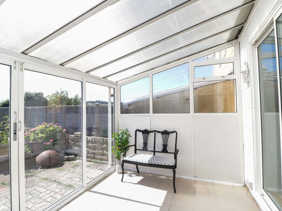 A conservatory with a chair and potted plant at 6 Newbridge Gardens Bath