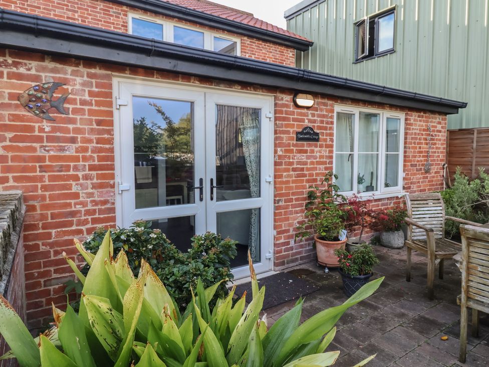 A patio with plants and a door at Blacksmith's Cottage in Ipswich