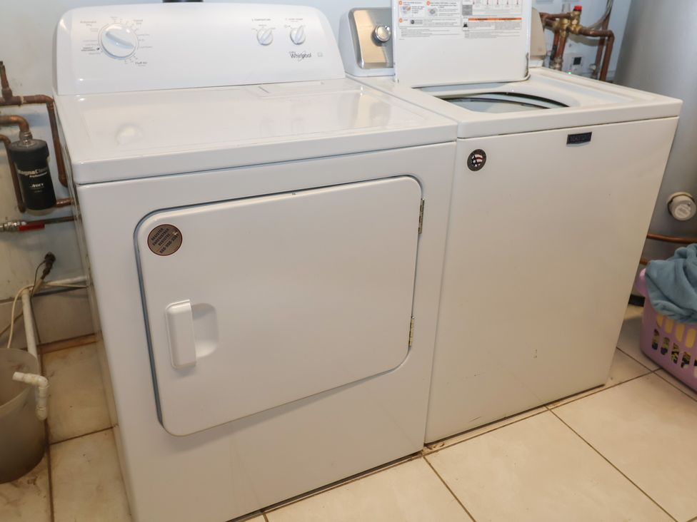 A washing machine and dryer in a laundry room at Blacksmith's Cottage, Ipswich