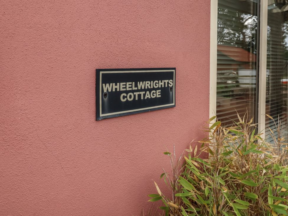 A nameplate for Wheelwright's Cottage at the exterior of a building in Ipswich
