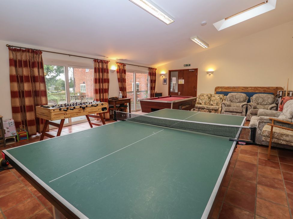 A game room with a ping pong table and foosball table at Wheelwright's Cottage Ipswich