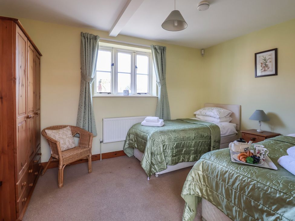 A bedroom with two beds and a window at Wheelwright's Cottage in Ipswich