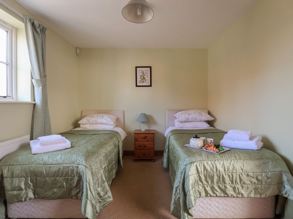 A bedroom with two twin beds and a breakfast tray at Wheelwright's Cottage in Ipswich