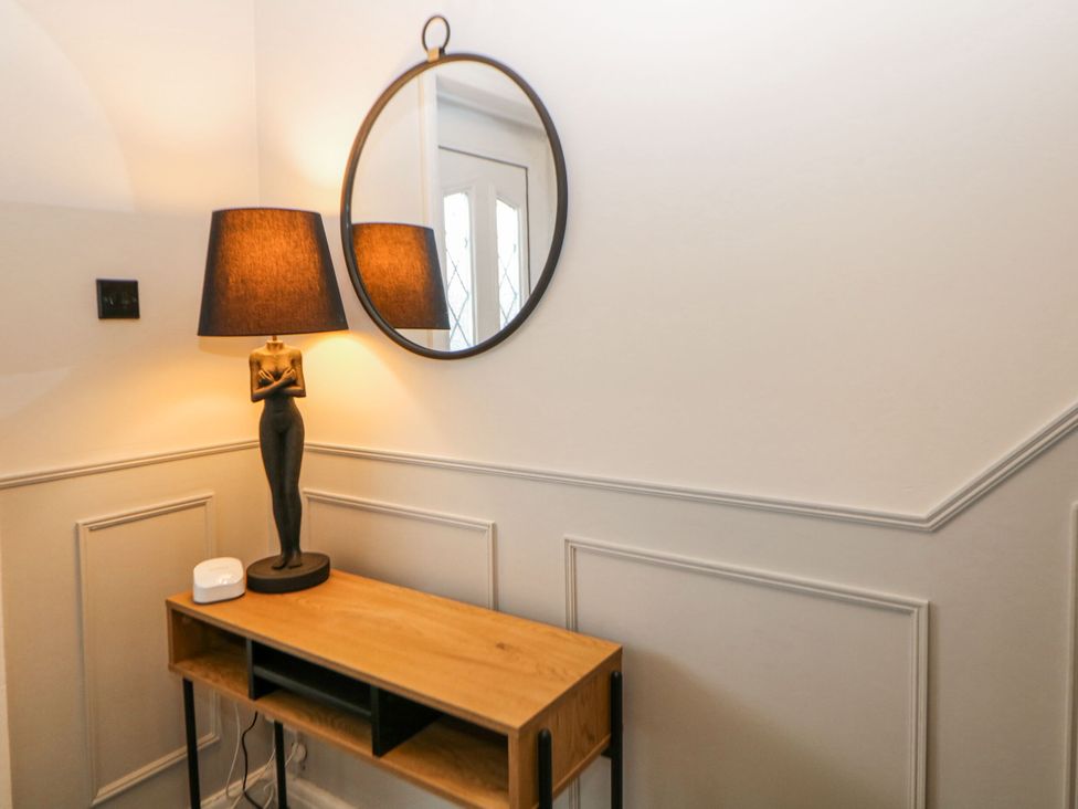 A hallway with a lamp and mirror above a console table at 37 Berry Hill Lane in Mansfield
