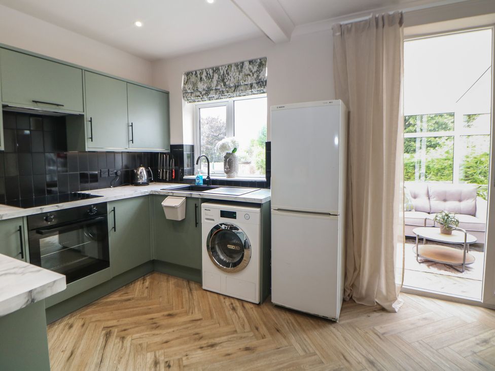 A kitchen with a washing machine and a fridge at 37 Berry Hill Lane in Mansfield