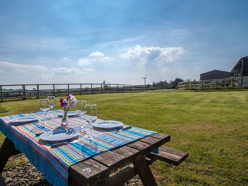 A garden setup with a table and glasses at Billy's Barn Bradworthy