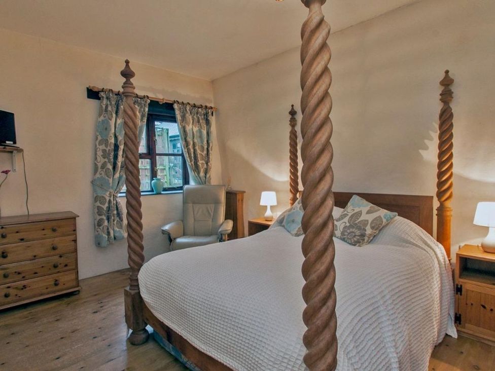 A bedroom with a bed and bedside tables at Billy's Barn in Bradworthy