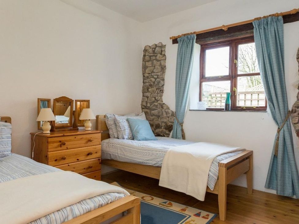 A bedroom with two beds and a chest of drawers at Billy's Barn in Bradworthy