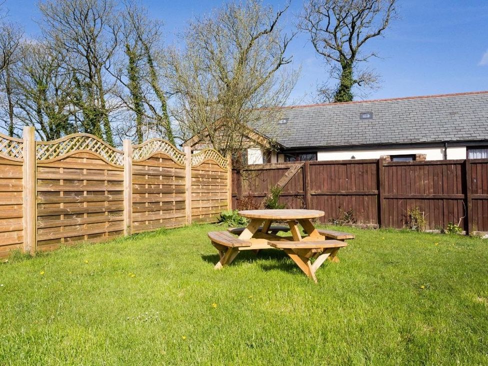 A garden with a table and benches at Billy's Barn in Bradworthy