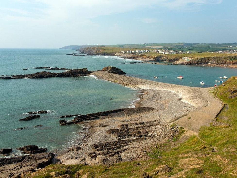 A coastal view with boats and rocks at Billy's Barn in Bradworthy