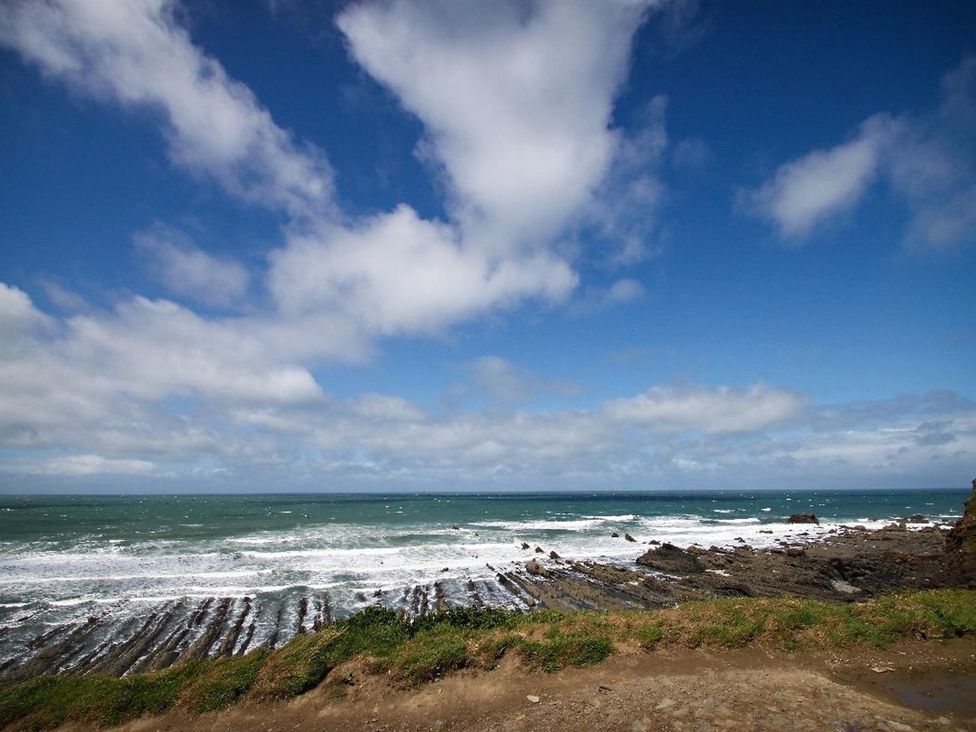 A coastal view of sea and rocky shore at Billy's Barn in Bradworthy