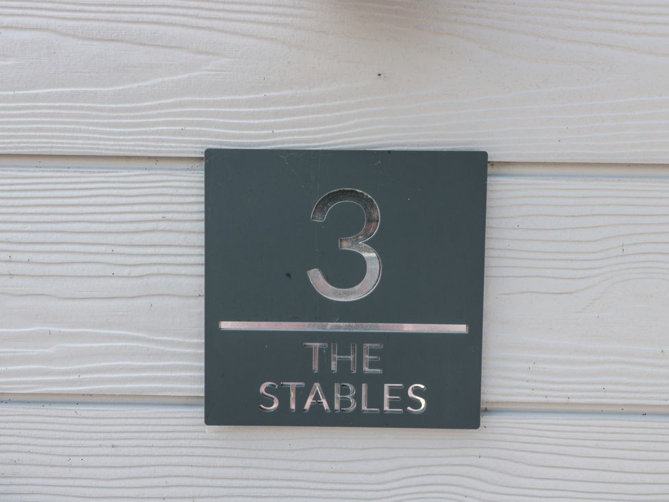 A sign displaying number 3 and The Stables at 3 The Stables Highbridge