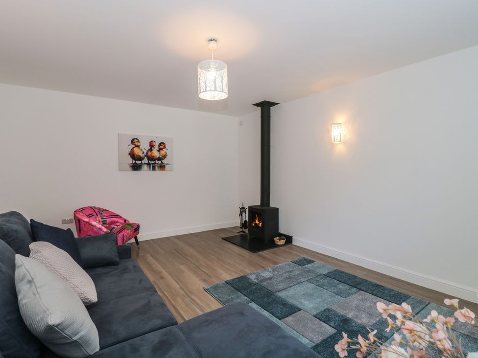 A living room with a fireplace and sofa at 3 The Stables in Highbridge