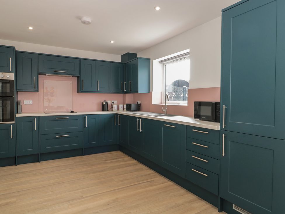 A kitchen with blue cabinets and a sink at 3 The Stables Highbridge