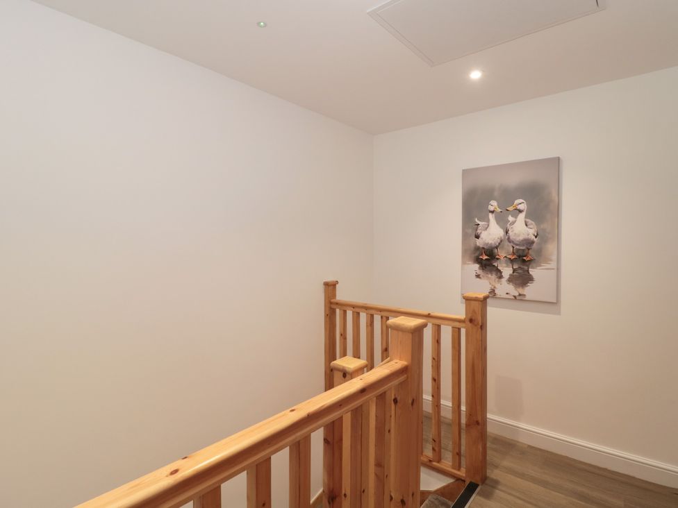 A stairwell with a wooden handrail and a painting at 3 The Stables Highbridge