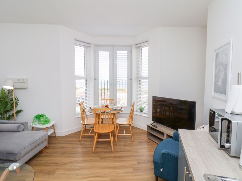 A living room with a dining area and television at Apartment 3 ( 2 bed ) in Redcar