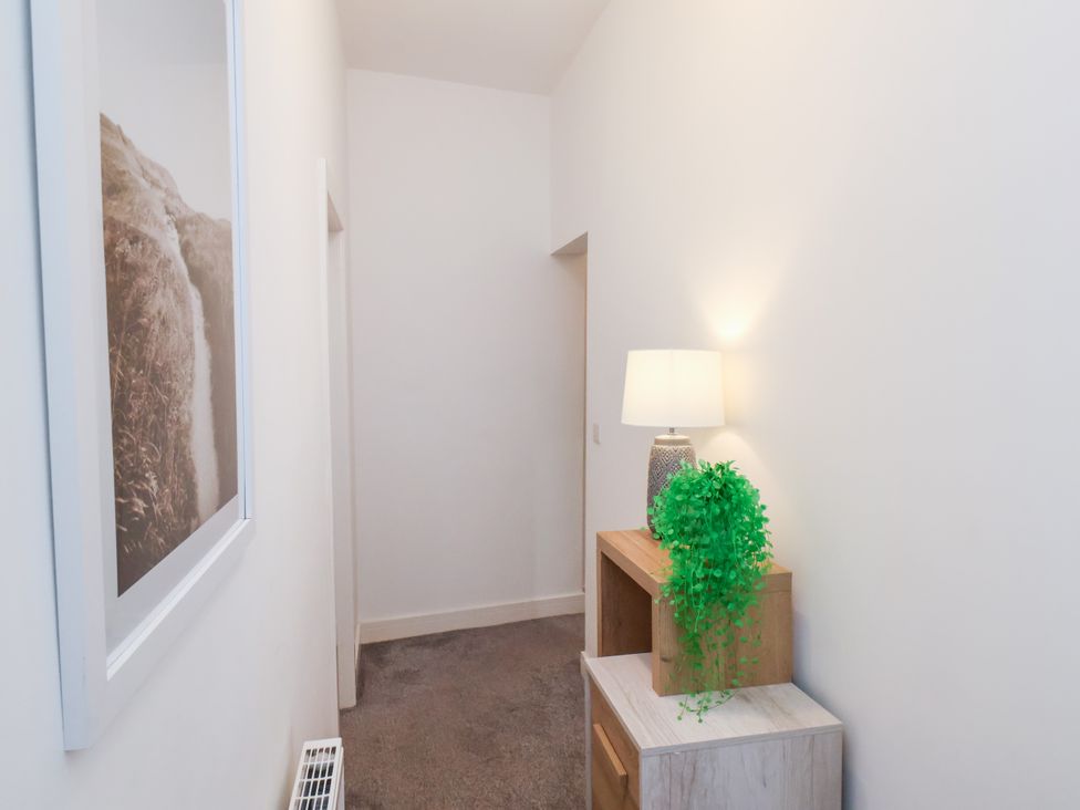 A hallway with a lamp and shelf at Apartment 3 (2 bed) Redcar