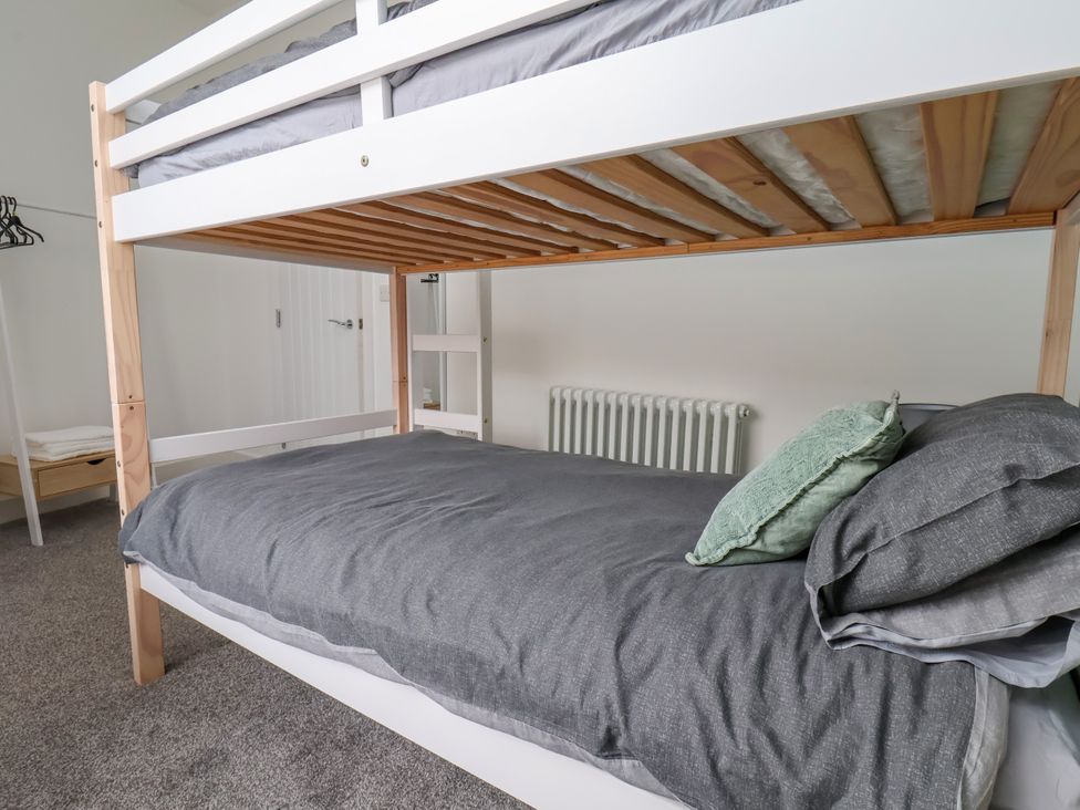 A bunk bed with gray bedding and a radiator at Apartment 3 (2 bed) in Redcar