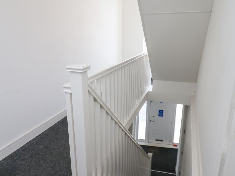 A staircase with a handrail and a door at Apartment 3 (2 bed) Redcar