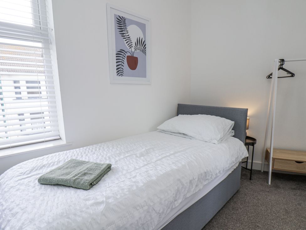 A bedroom with a single bed and wall art at Glenholme Apartment 3 Redcar