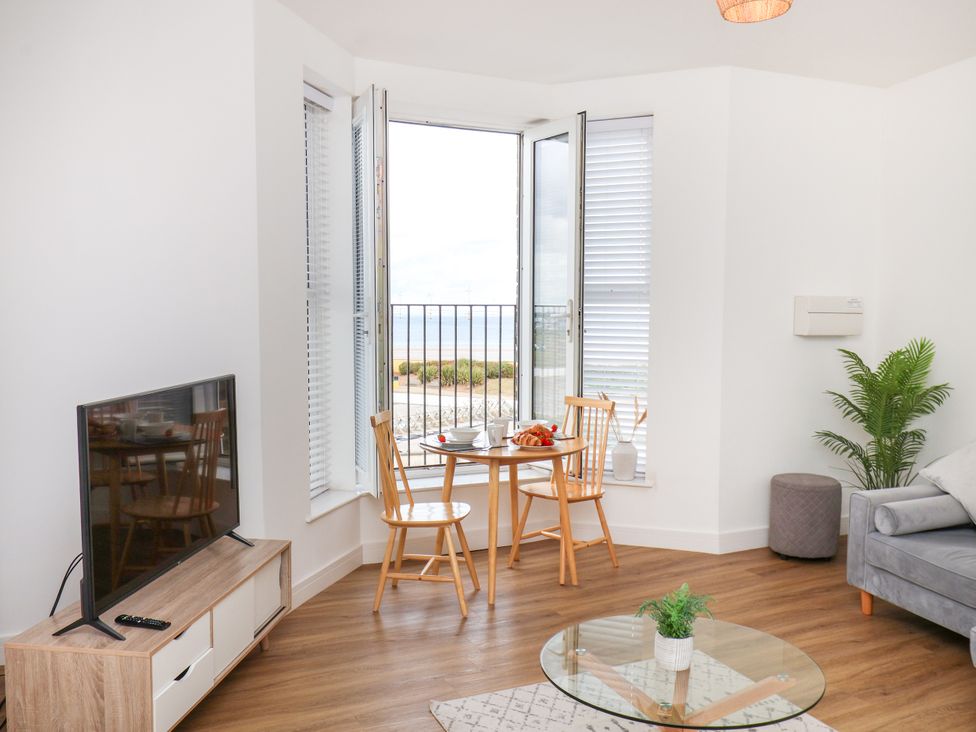 A living room with a sofa and a table by the window at Apartment 4 ( 1 bed ) in Redcar
