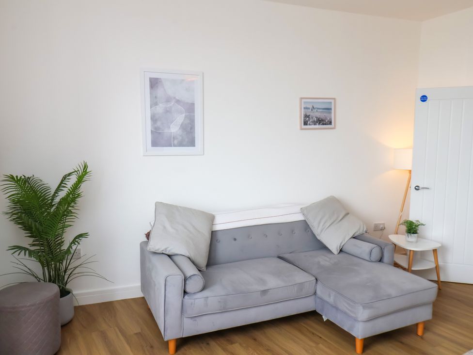 A living room with a sofa and a potted plant at Apartment 4 ( 1 bed ) in Redcar