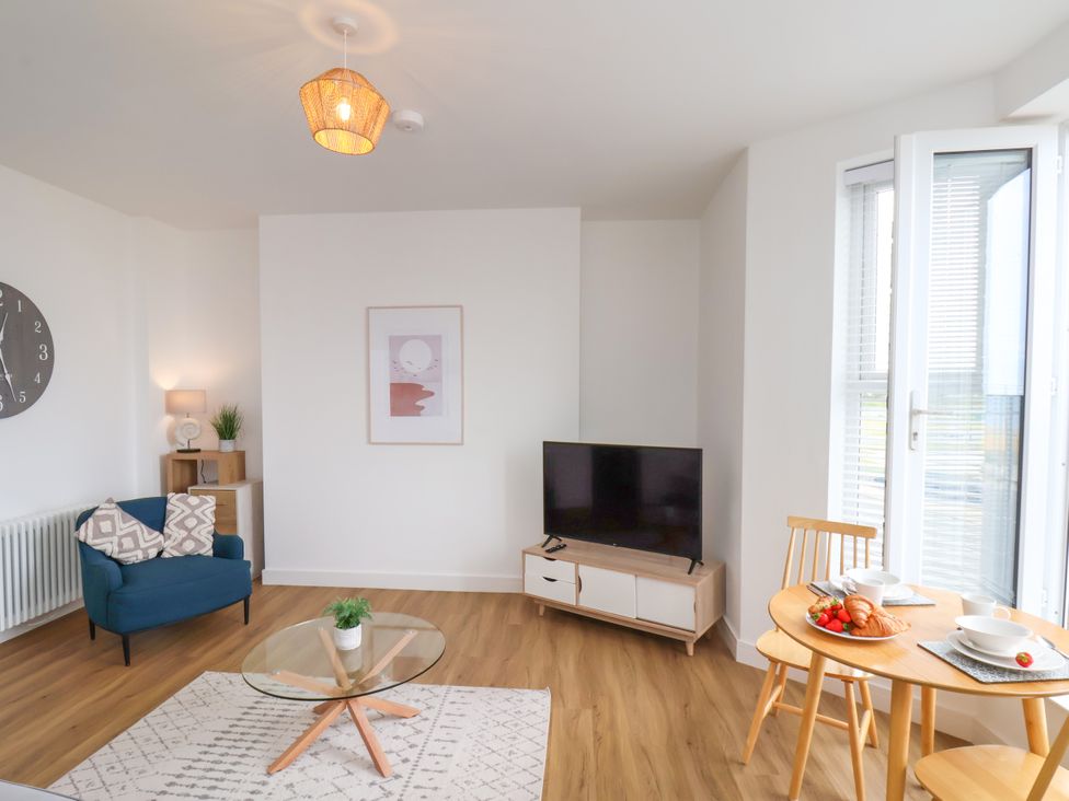 A living room with a tv and dining area at Apartment 4 (1 bed) Redcar