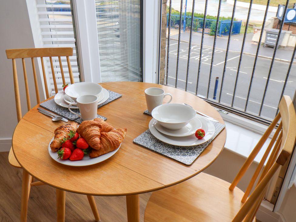 A dining room table set with croissants, strawberries, cups and bowls at Apartment 4 ( 1 bed ) Redcar